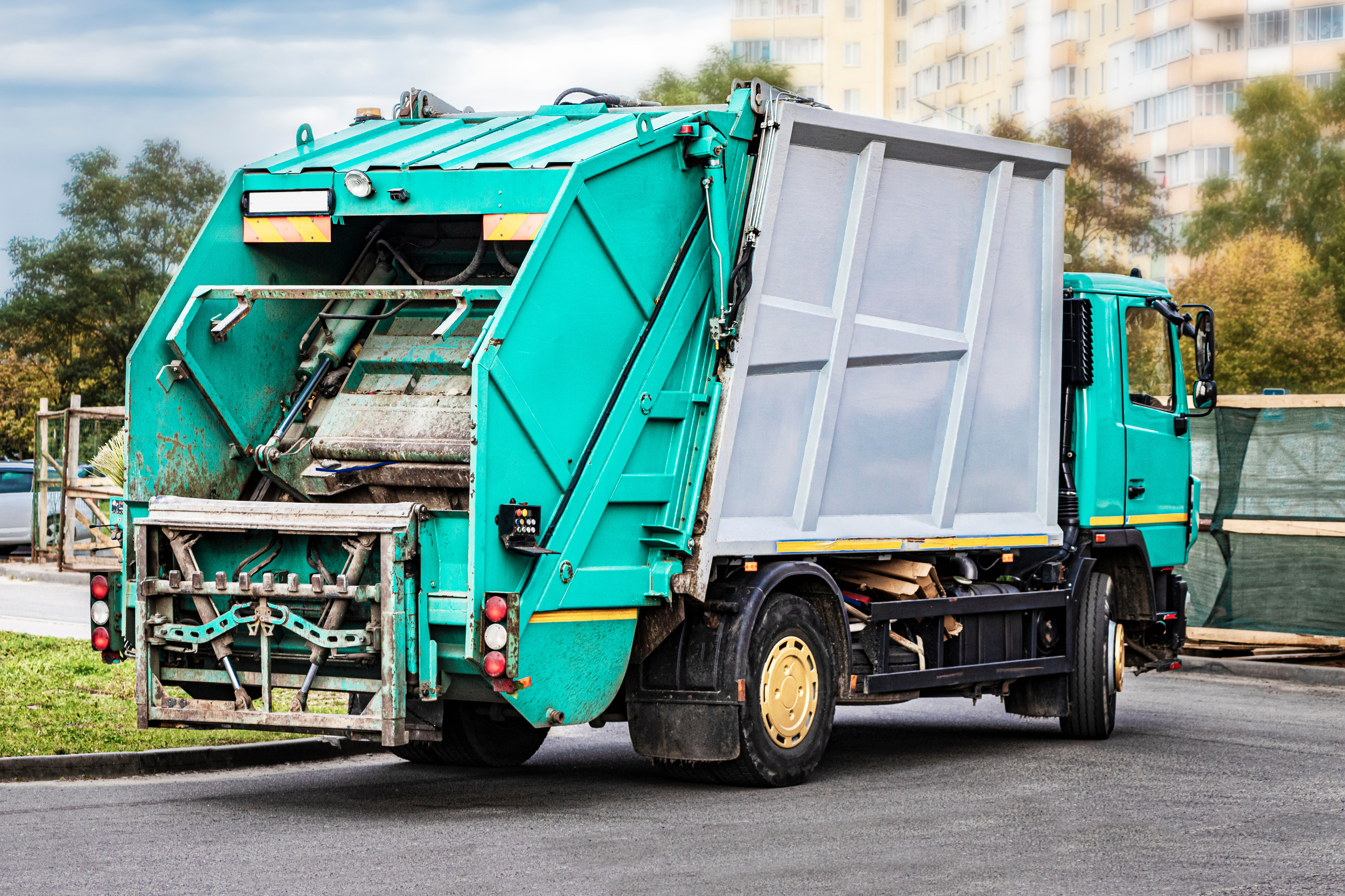 A garbage truck picks up garbage in a residential area. Separate collection and disposal of garbage. Garbage collection vehicle. A garbage truck picks up garbage in a residential area. Separate collection and disposal of garbage. Garbage collection vehicle.