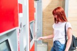 Woman uses cash to buy ticket at train terminal Woman uses cash to buy ticket at train terminal