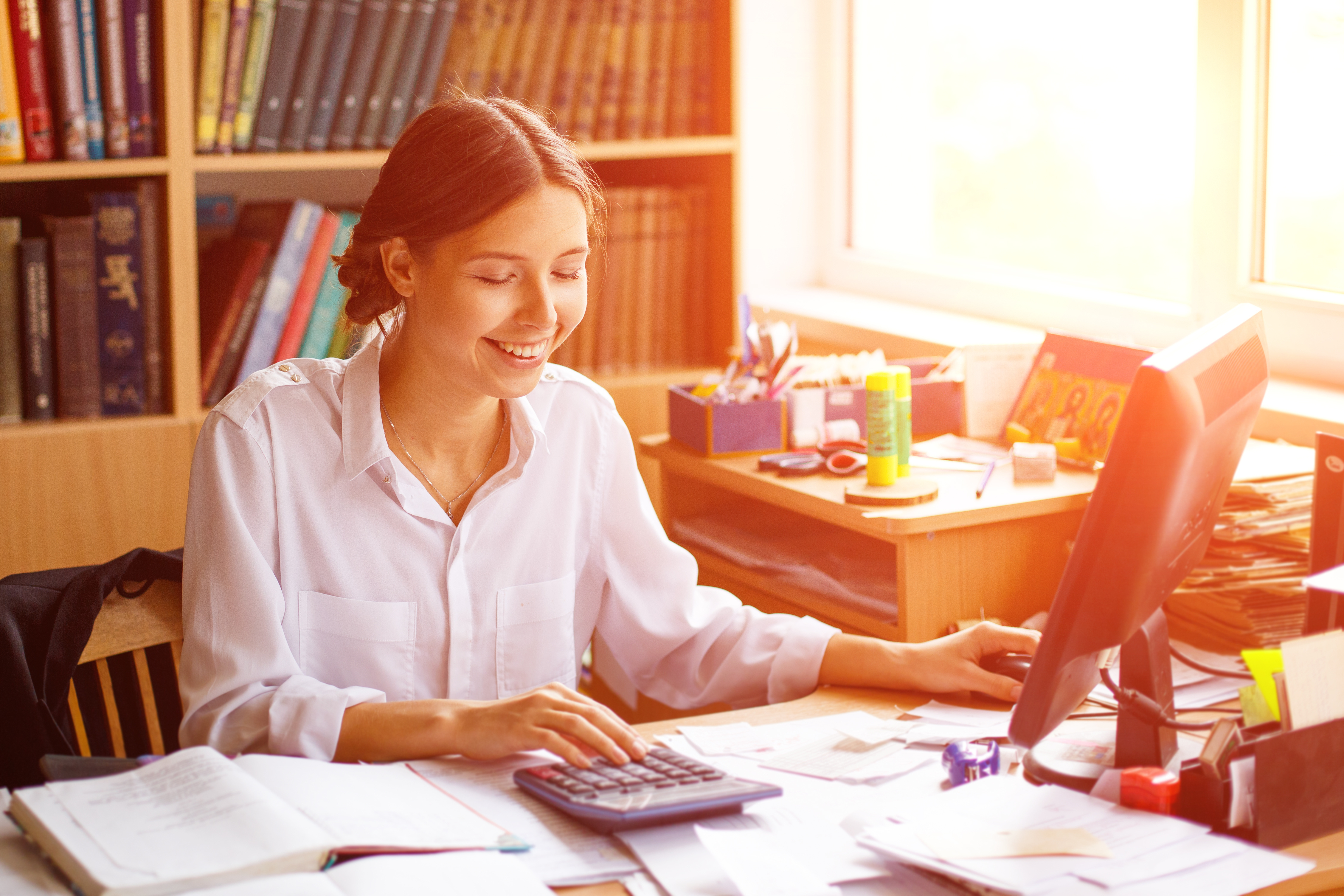 Office, young business woman signs documents in white shirt sitting at table. Office, young business woman signs documents in white shirt sitting at table.